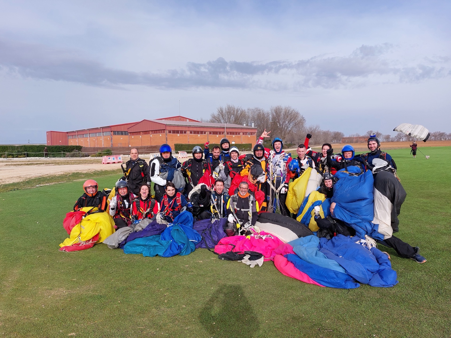 The group celebrating in the landing area with their canopies gathered up